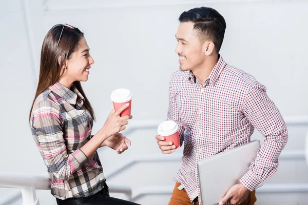Joven hombre y mujer hablando mientras bebe café durante el descanso —  Fotos de Stock