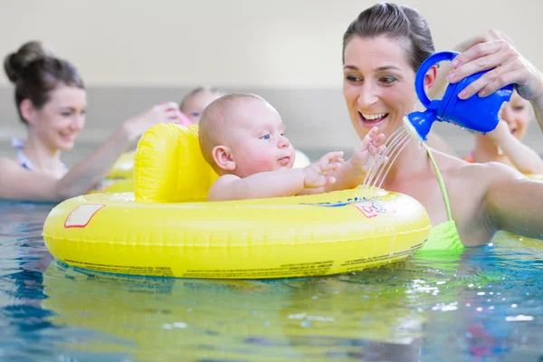 Madres y niños divirtiéndose juntos jugando con juguetes en la piscina — Foto de Stock