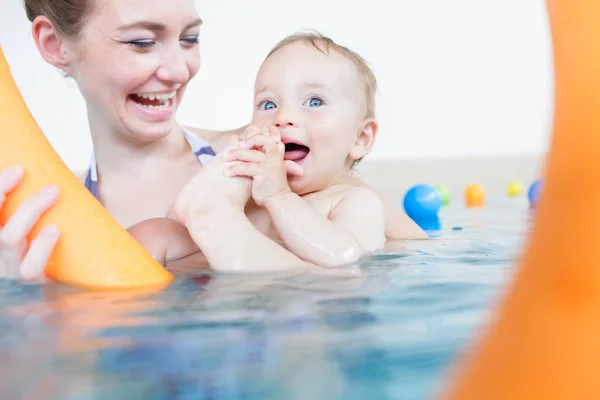 Madres siendo feliz acerca de sus bebés jugando entre sí en la piscina —  Fotos de Stock