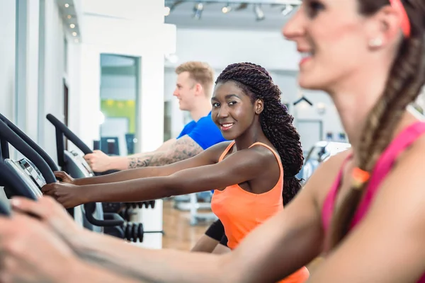 Mujer sonriendo corriendo en la cinta en el gimnasio moderno club de salud —  Fotos de Stock