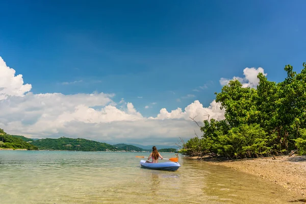 Jovem mulher remando durante as férias em um destino de viagem idílico — Fotografia de Stock