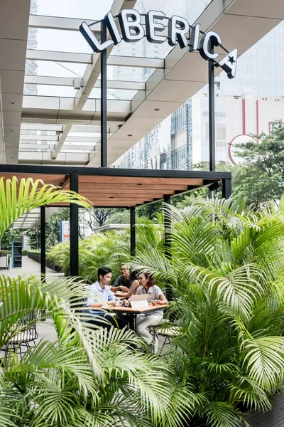 Personer som sitter ned utomhus på en modern cafeteria i Asien — Stockfoto