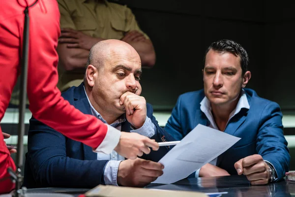 Middle-aged man calling his attorney during a difficult police interrogation — Stock Photo, Image