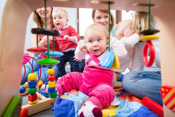 Mignonne bébé fille regardant vers le haut tout en s'asseyant sur le sol à la maison — Photo