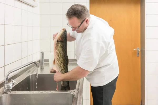 Koch entkernt Karpfenfische, um sie später zuzubereiten — Stockfoto