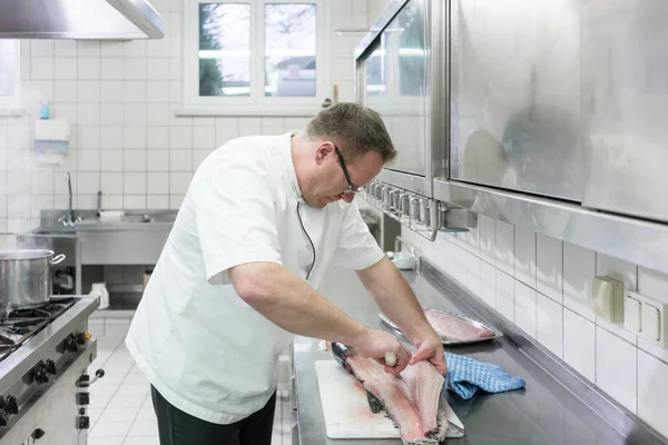 Chef in Restaurantküche filetiert Karpfen — Stockfoto