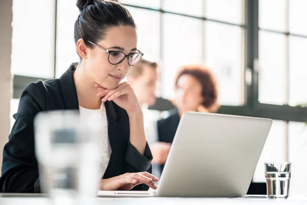 Mujer de negocios concentrada leyendo información sobre el ordenador portátil —  Fotos de Stock