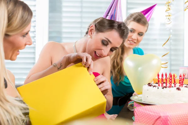 Gyönyörű nő megnyitása egy ajándék doboz, miközben ünnepli születésnapját — Stock Fotó
