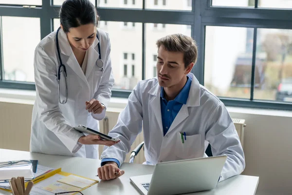 Jeune femme médecin demandant conseil à son collègue expérimenté — Photo