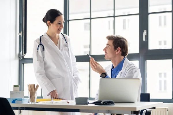 Jonge vrouwelijke arts vraagt om advies van haar ervaren collega — Stockfoto