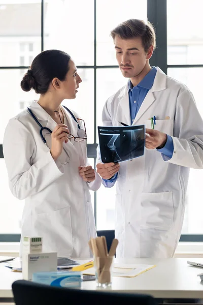 Twee jonge toegewijde artsen analyseren samen een radiografie van — Stockfoto
