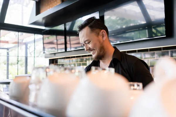 Felice giovane uomo che lavora come barista dietro il bancone del bar — Foto Stock