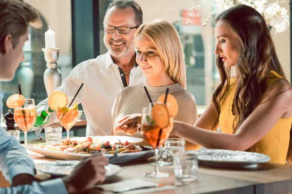 Sarışın güzel kadın şık bir restoranda yemeğe en iyi arkadaşları ile