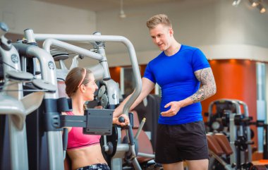 Modern bir fitness güzel bir kadın rehberlik yakışıklı kişisel antrenör