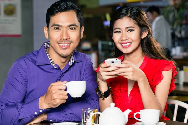 Retrato de una joven y feliz pareja asiática relajándose juntos en la cafetería — Foto de Stock