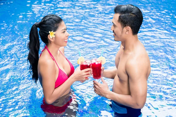 Pareja tomando bebidas en la piscina en Asia — Foto de Stock