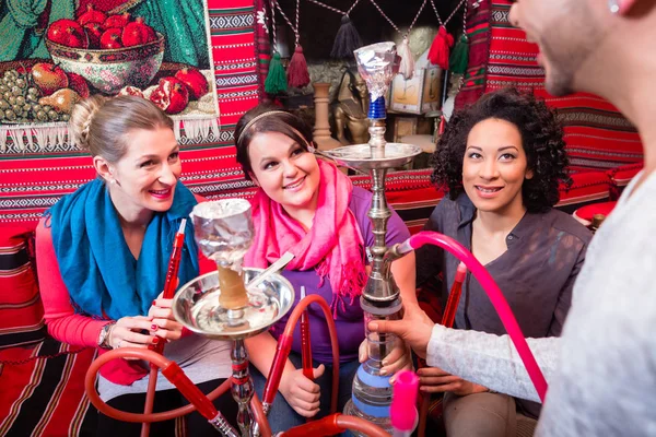 Kadınlar ve erkekler bir nargile shisha Cafe sunulmakta göre gruplandırma