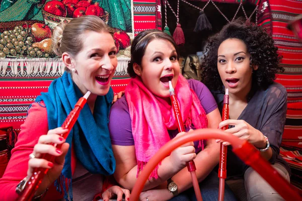 Women enjoying hookah or shisha in oriental cafe — Stock Photo, Image