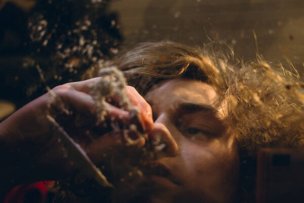 Drug addicted teenage boy holding a rolled bill while snorting