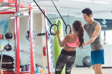 Şınav jimnastik halkaları üzerinde yaparken gülümseyen güzel genç kadın