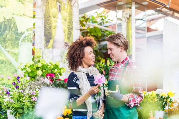 Cheerful female customer buying flowers at the advice of a helpful vendor — Stock Photo, Image