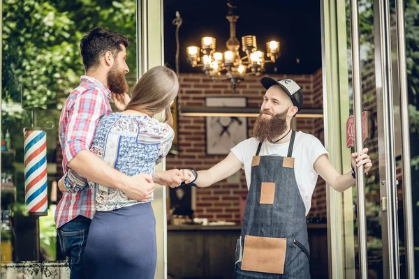 Coole Friseurin gibt einer glücklichen Kundin vor der Tür einen Faustschlag — Stockfoto