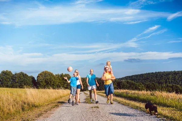 Familia paseando a su perro en un camino de tierra — Foto de Stock