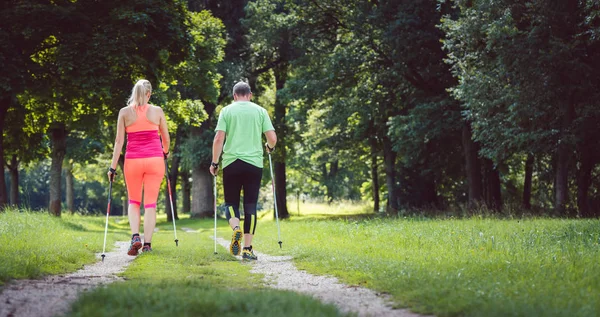 Casal fazendo Nordic Walking para o esporte — Fotografia de Stock