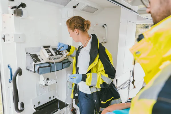 Парамедики используют медицинские технологии в машине скорой помощи — стоковое фото