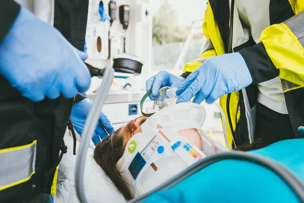 Médico de emergência cuidando de mulher gravemente ferida — Fotografia de Stock