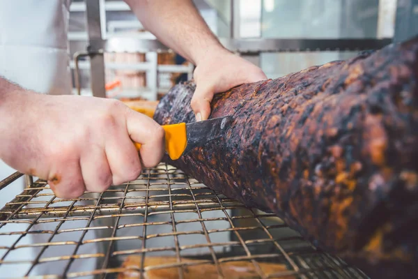 肉屋、オーブンで肉を切る — ストック写真