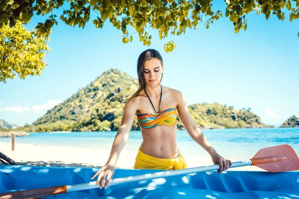 Vrouw met een kajak op een eiland tegenover strand — Stockfoto