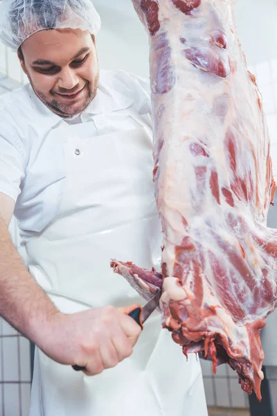 Slager snijden aan de stukken vlees uit het karkas — Stockfoto