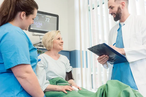 Arzt und Krankenschwester im Gespräch mit dem Patienten im Aufwachraum des Krankenhauses — Stockfoto