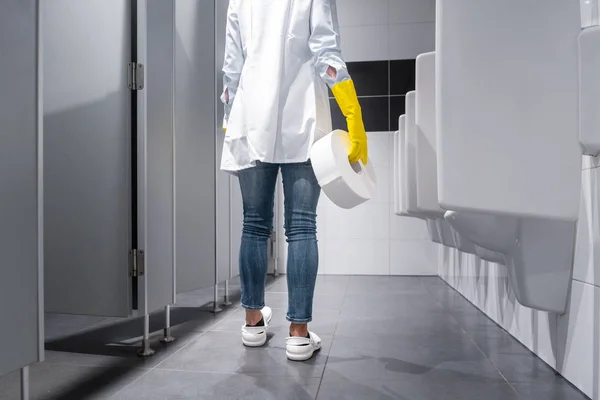 Уборщица меняет бумагу в общественном туалете — стоковое фото