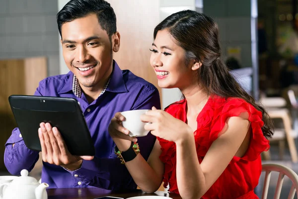 Pasangan bahagia menonton bersama-sama sebuah video lucu online pada tablet — Stok Foto