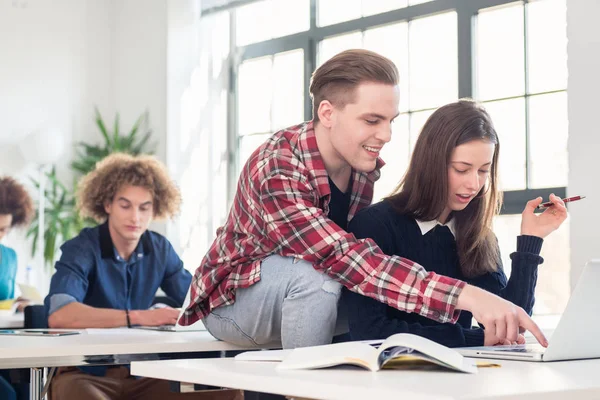 Dos alegres estudiantes del milenio riendo mientras se sientan juntos —  Fotos de Stock