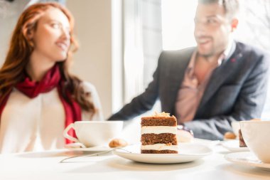 Genç bir çift masada kahve ile lezzetli katmanlı pasta servis