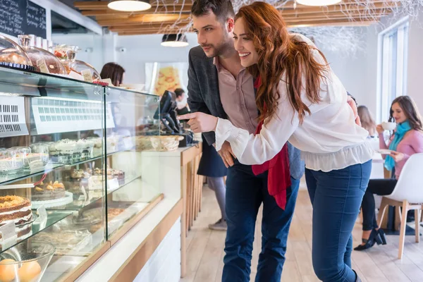 Bella donna che sceglie una deliziosa torta mentre in piedi accanto al suo fidanzato — Foto Stock