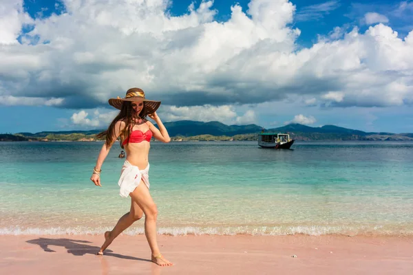 Joyeux jeune femme marchant à travers l'eau de mer peu profonde sur la plage — Photo