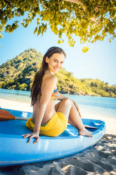 Beautiful woman sitting on boat close to the ocean beach