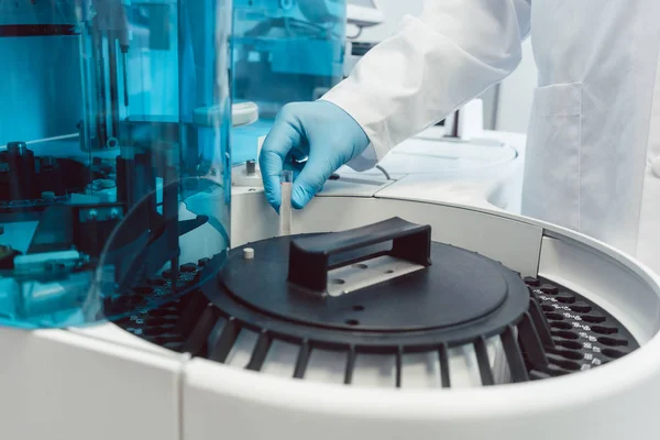 Лабораторний технік заряджає центрифугу трубами людської крові — стокове фото