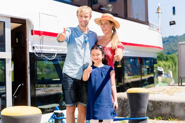 Rodina na dovolené před lodí ukazuje palec — Stock fotografie