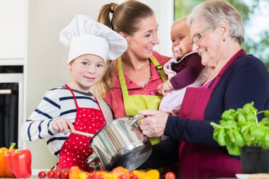 Anne, baba, büyükanne ve torunu birlikte mutfakta yemek hazırlama