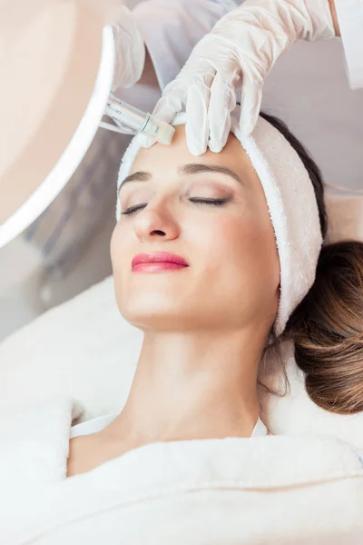 Gros plan sur le visage d'une femme relaxante lors d'un lifting non chirurgical — Photo