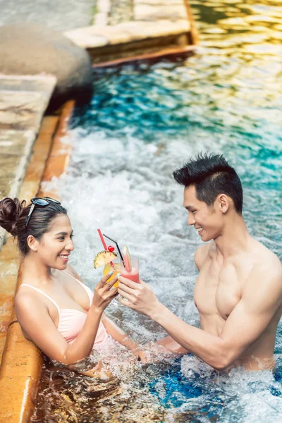 Junger Mann flirtet mit einer attraktiven Frau in einem trendigen Schwimmbad — Stockfoto