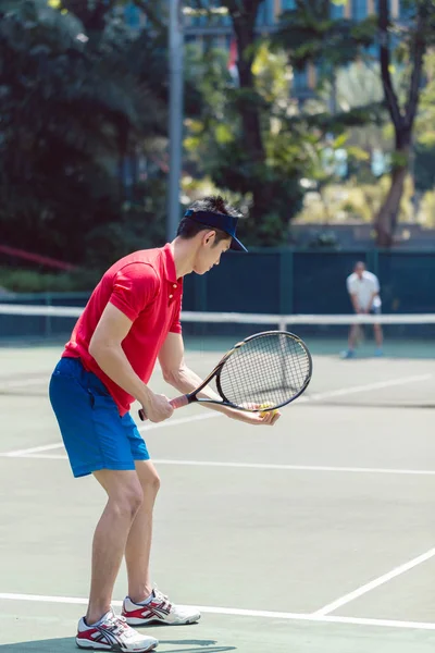Giocatore di tennis asiatico pronto a servire all'inizio di una partita mista di doppio — Foto Stock