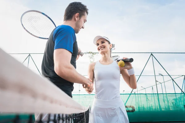 Erkek ve kadın tenis maçından sonra tokalaşırken — Stok fotoğraf