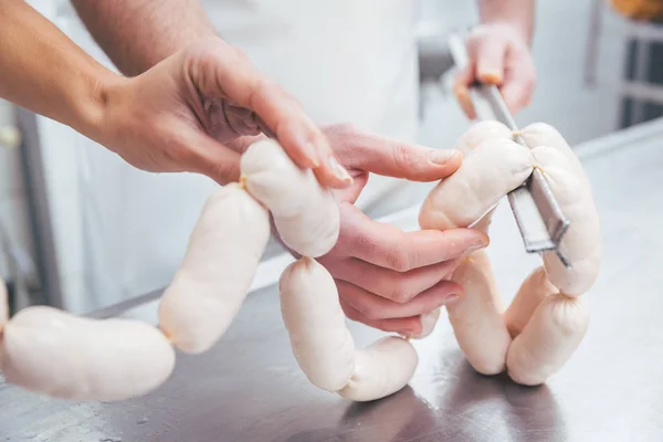 Butcher in butchery filling sausages — Stock Photo, Image