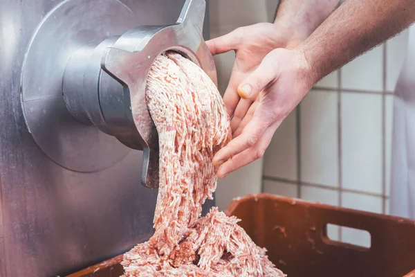 Darált hús áramlik ki a darálóban a mészárlás — Stock Fotó